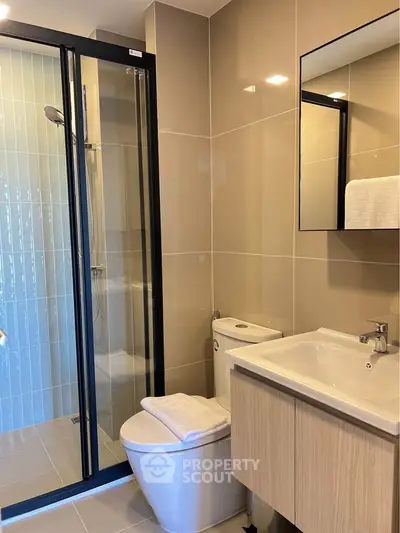 Modern bathroom with sleek shower and elegant vanity in contemporary apartment.