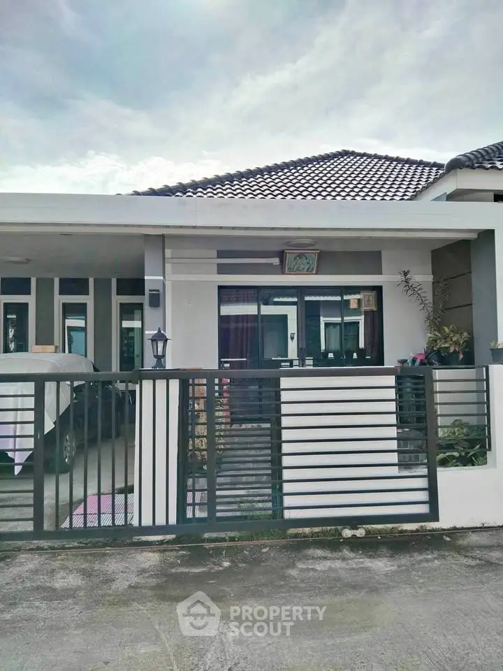 Charming single-story home with modern facade and gated entrance, perfect for cozy living.