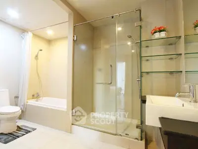 Modern bathroom with glass shower, bathtub, and sleek fixtures in a bright, elegant setting.