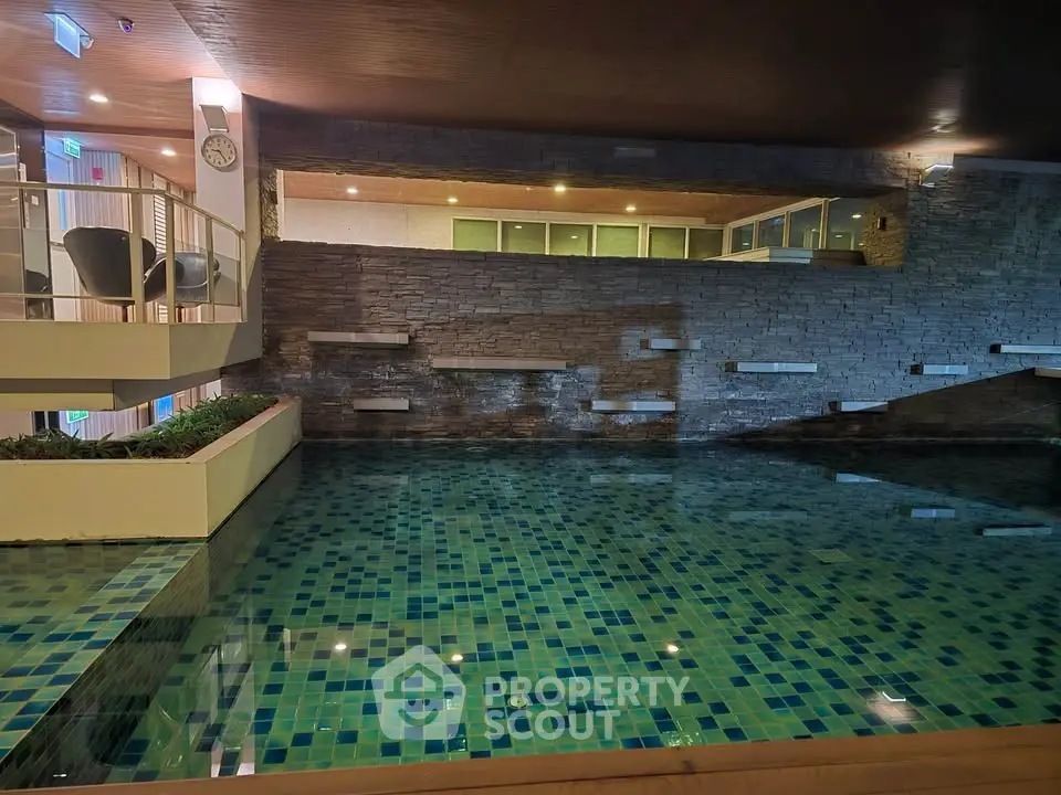 Luxurious indoor pool with modern design and ambient lighting in upscale residential building.