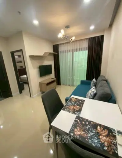 Modern living room with stylish decor and open layout, featuring a cozy sofa and dining area.