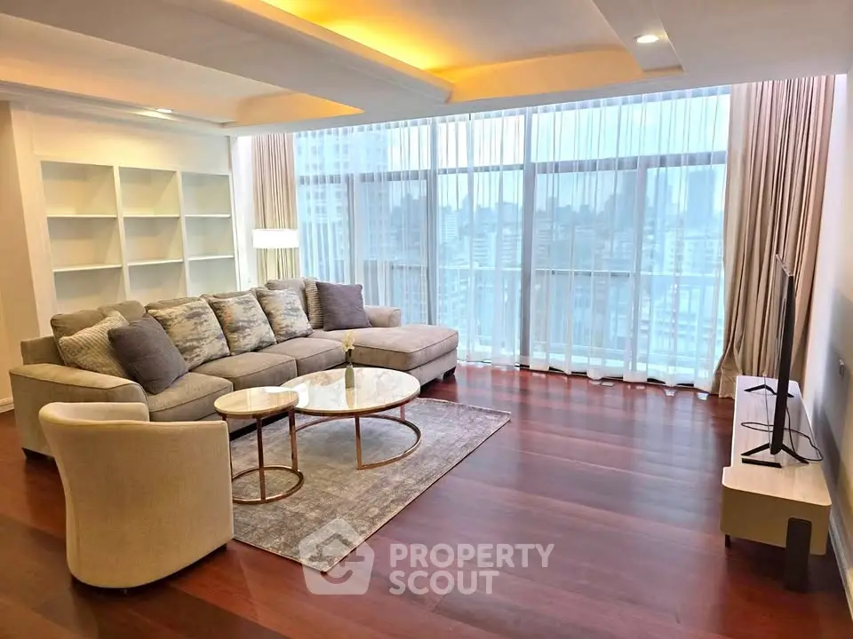 Spacious modern living room with city view, elegant furniture, and floor-to-ceiling windows.