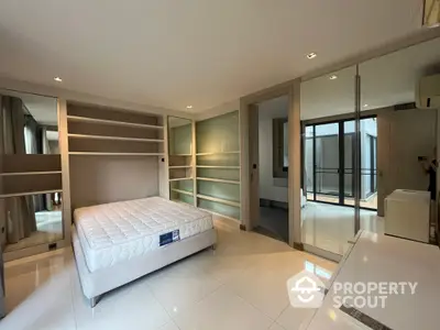 Spacious bedroom with modern design, large bed, built-in wardrobes, and ample natural light from floor-to-ceiling windows leading to a private balcony.