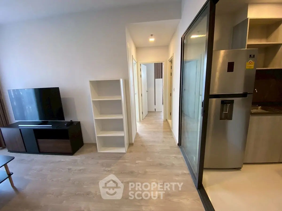 Modern apartment interior with open layout, featuring sleek kitchen and spacious living area.