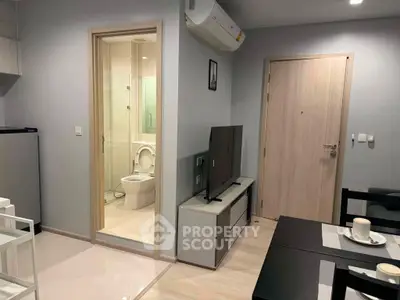 Modern apartment interior with open living area and visible bathroom