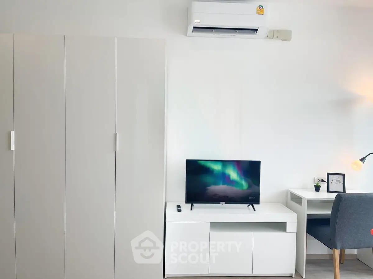 Modern living room with sleek white furniture and air conditioning unit, perfect for a cozy urban lifestyle.
