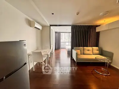 Modern open-plan living room with sleek furniture and wooden flooring.