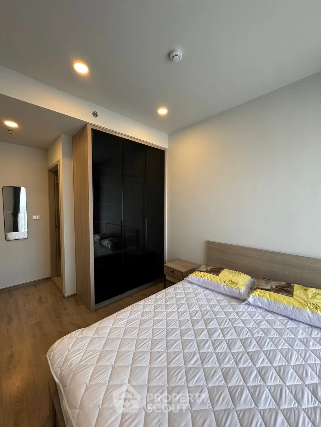 Modern bedroom with sleek wardrobe and cozy bed in stylish apartment