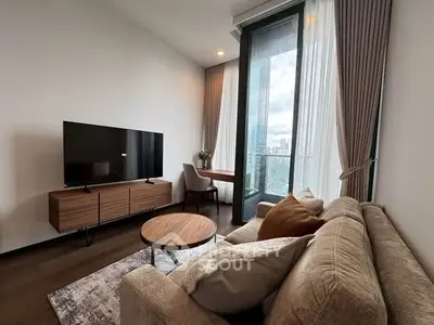 Modern living room with large TV and city view from balcony