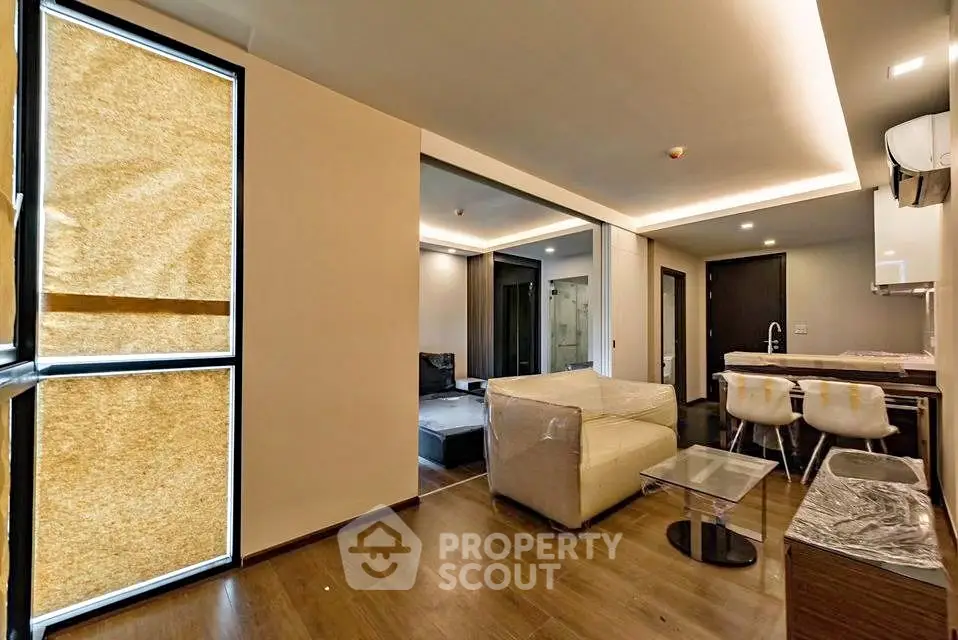 Modern open-layout living room with stylish kitchen and cozy seating area.