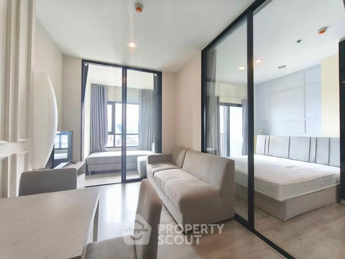 Modern apartment interior with spacious living room and bedroom, featuring large windows and sleek design.
