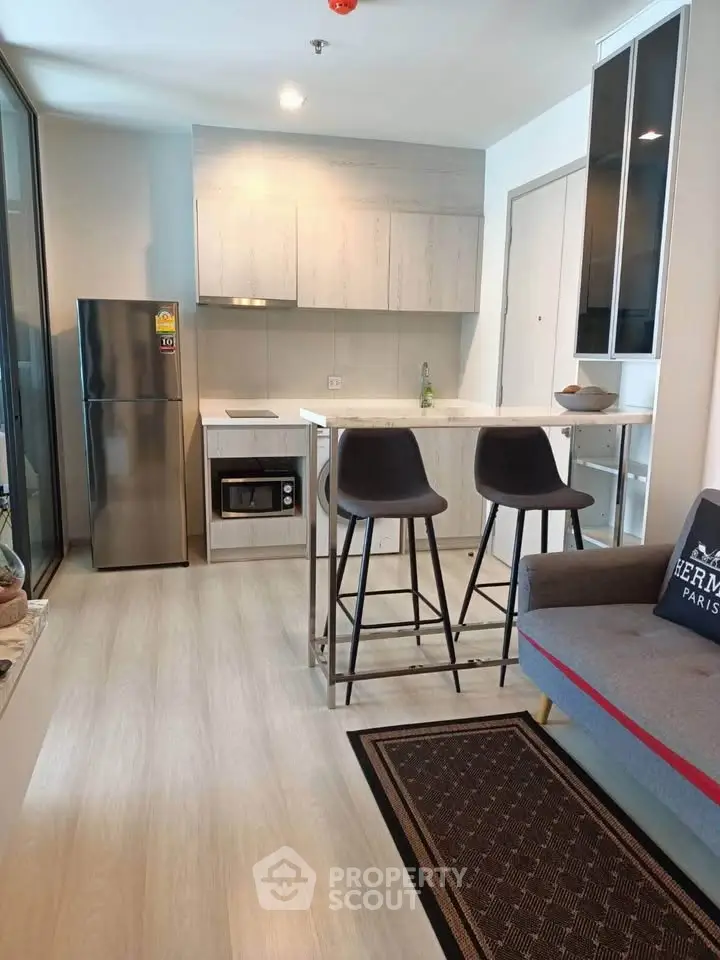 Modern kitchen with sleek design, featuring stainless steel appliances and cozy breakfast bar.