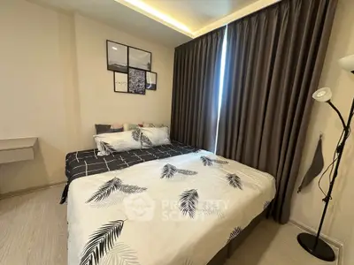 Cozy bedroom with modern decor and large window, featuring stylish bedding and elegant curtains.