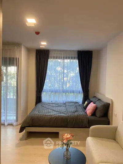 Cozy bedroom with large windows and modern decor, perfect for relaxation.