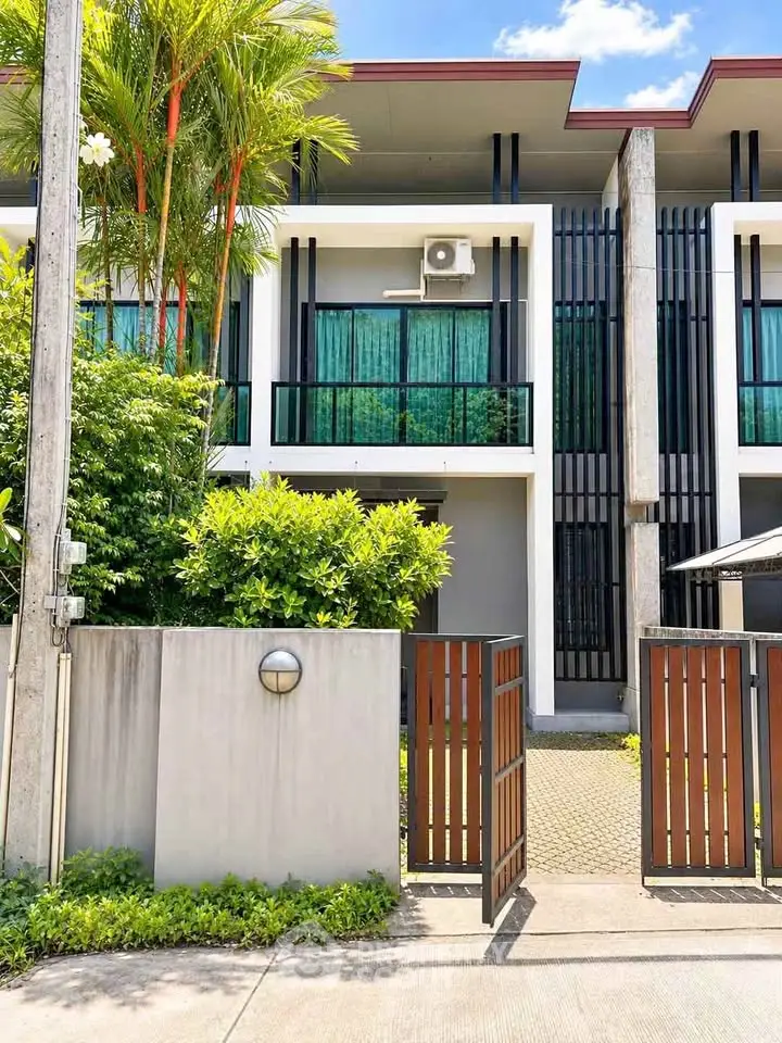 Modern townhouse exterior with lush greenery and sleek design, perfect for contemporary living.