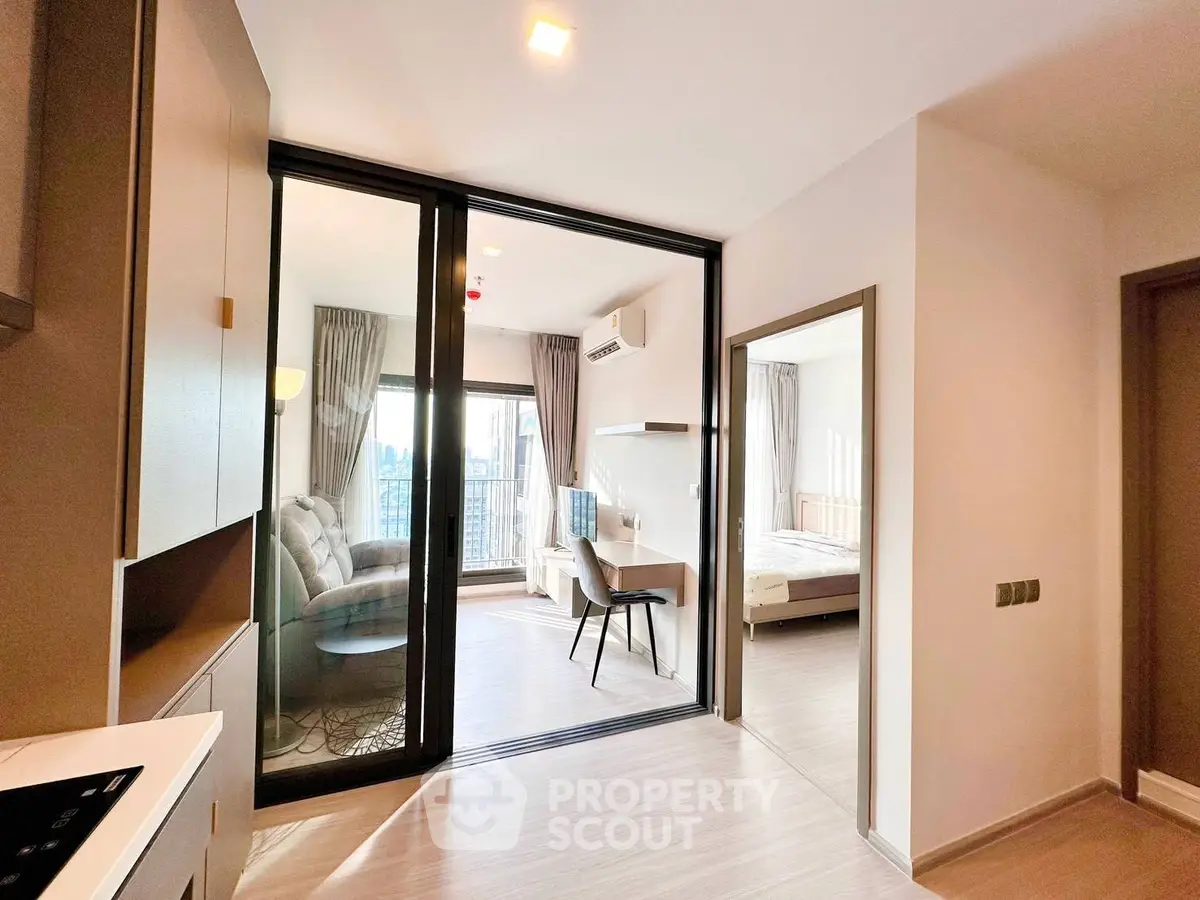 Modern apartment interior with open layout, featuring a cozy living room and bedroom with large windows.