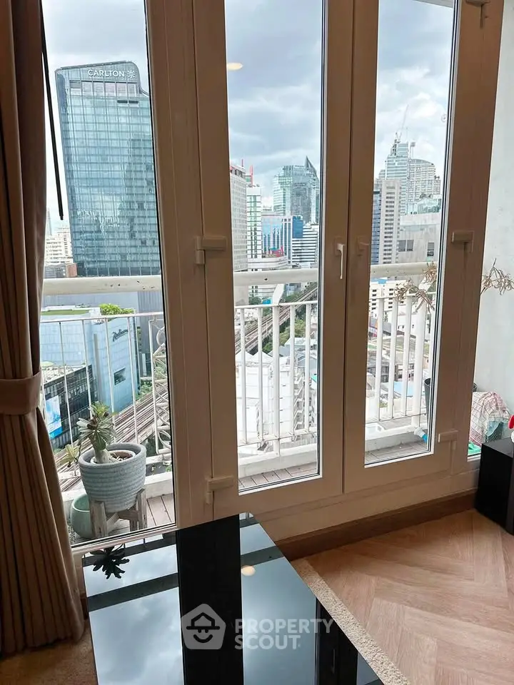 Stunning city view from modern apartment balcony with floor-to-ceiling windows and elegant interior design.