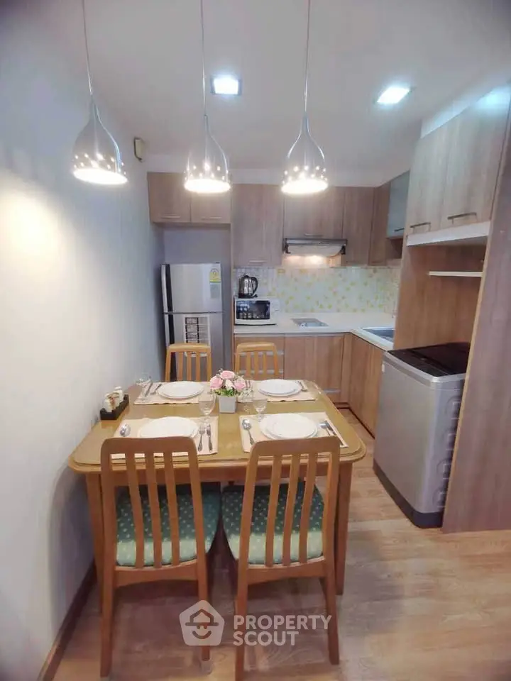 Charming kitchen with modern appliances and cozy dining area in a stylish apartment.