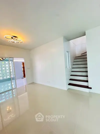 Spacious modern living room with elegant staircase and unique lighting fixture
