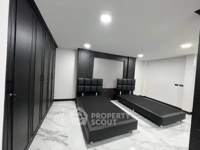 Modern bedroom with sleek black furniture and marble flooring