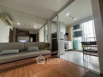 Modern open-plan living room with kitchen, featuring sleek design and natural light.