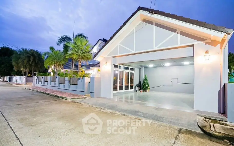 Charming modern house with spacious garage and lush palm trees, perfect for serene living.