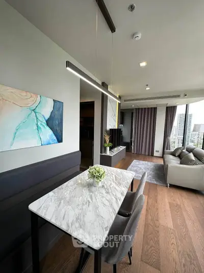 Modern living room with elegant dining area and city view, featuring stylish decor and natural light.