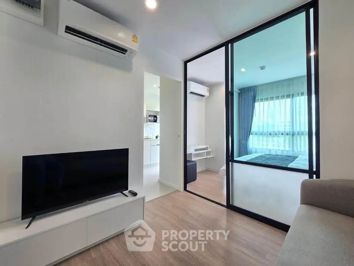 Modern apartment interior with open living room and bedroom view
