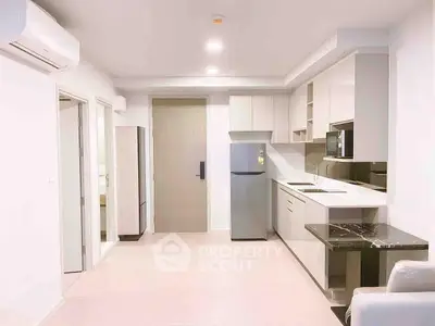 Modern kitchen with sleek cabinetry and stainless steel appliances in a bright apartment.