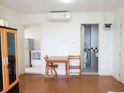 Cozy apartment interior with dining area and view into kitchen and bathroom.