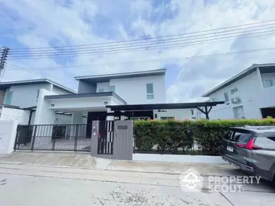 Modern two-story house with gated entrance and driveway in suburban neighborhood