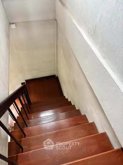 Charming wooden staircase with sleek railing in a cozy home interior, perfect for adding character and warmth.
