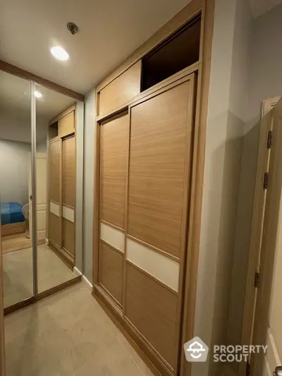 Spacious walk-in closet with wooden sliding doors and mirrored panels in modern home.