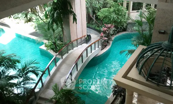Luxurious residential pool with lush greenery and elegant bridge
