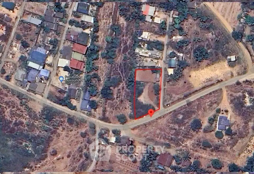 Aerial view of a residential area with marked plot of land for sale.