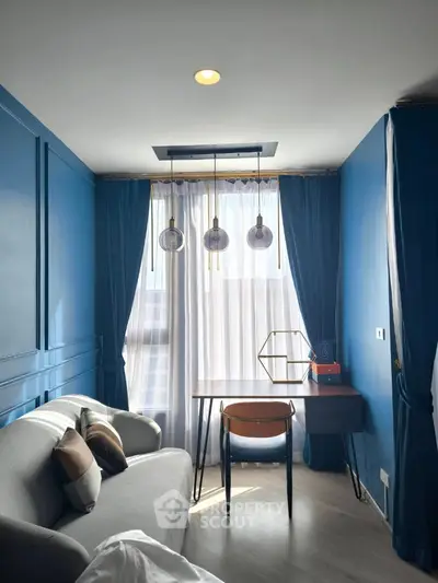 Stylish modern living room with blue walls, cozy sofa, and elegant lighting.