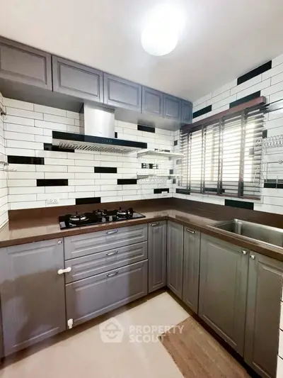 Modern kitchen with sleek cabinetry and gas stove in stylish apartment.