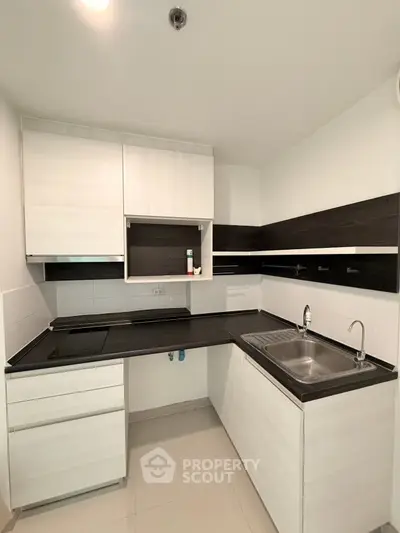 Modern kitchen with sleek black countertops and white cabinetry