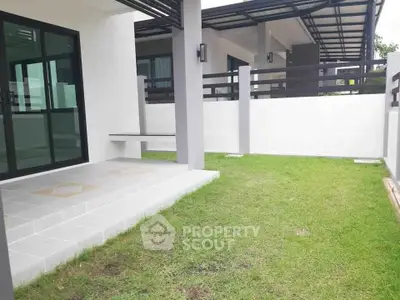 Modern home exterior with green lawn and stylish patio area