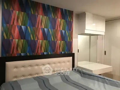 Stylish bedroom with colorful geometric accent wall and modern furnishings