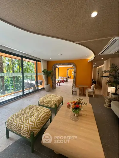Luxurious living room with modern decor and large windows overlooking lush greenery.