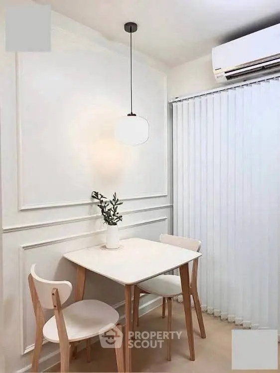 Chic minimalist dining area with modern pendant light and air conditioning, perfect for cozy meals.