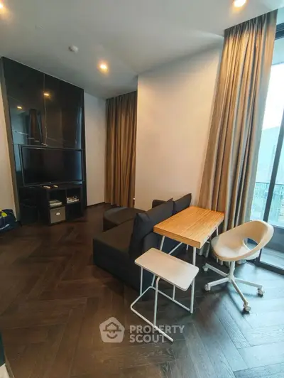Modern living room with sleek furniture and large windows offering natural light.