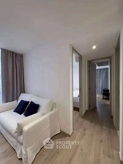 Modern apartment hallway with cozy seating and wooden flooring