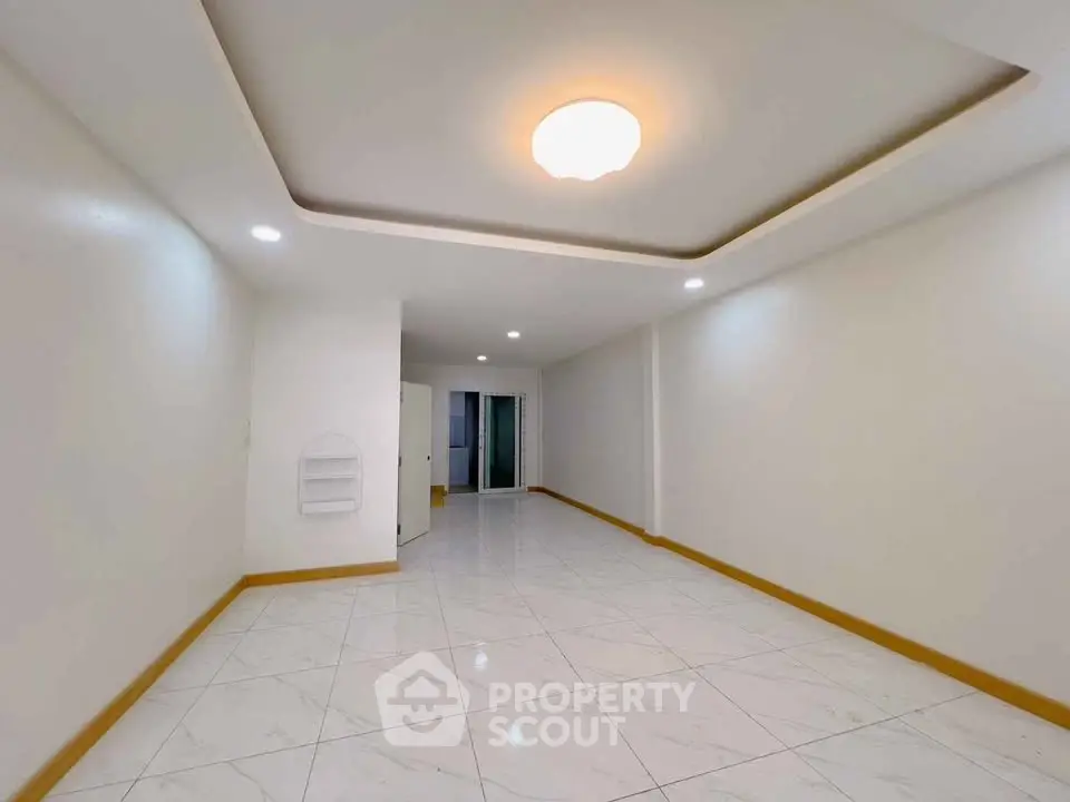 Spacious empty room with modern lighting and glossy tiled floor