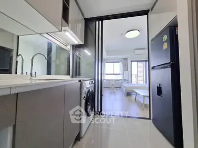 Modern apartment kitchen with washing machine and open layout to living room