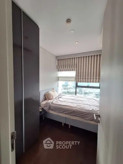 Cozy bedroom with large window and modern decor in urban apartment