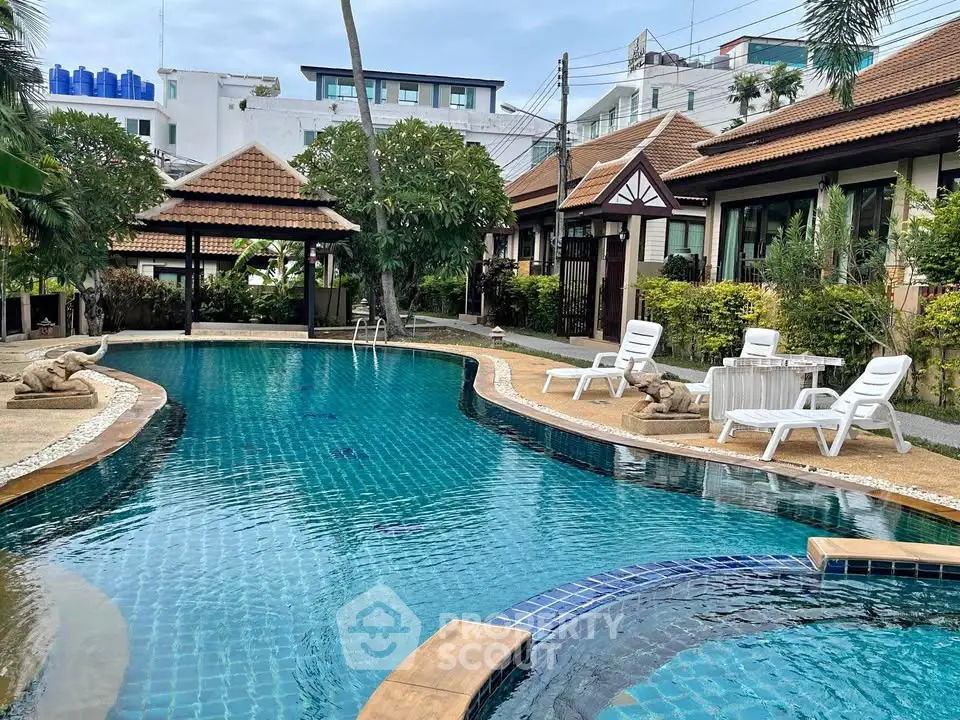 Luxurious tropical poolside with serene garden and elegant villas, perfect for relaxation and leisure.