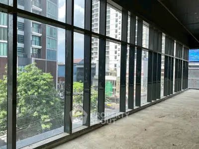Spacious interior with large windows offering urban cityscape views.
