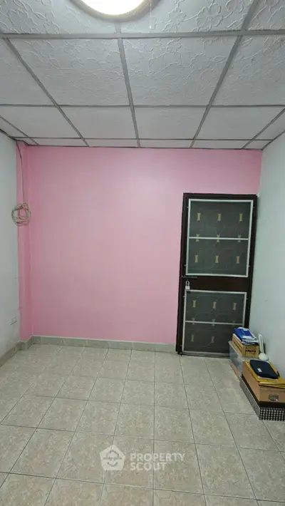 Cozy room with pink accent wall and tiled flooring, perfect for creative customization.